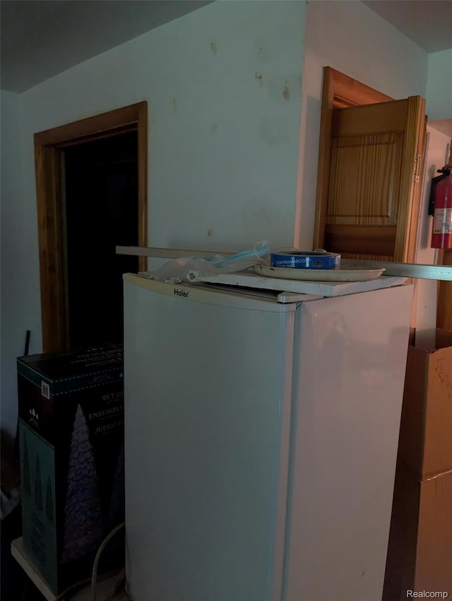 150 University Dr, Howell, MI 48843 - kitchen view of fridge and a fire extinguisher