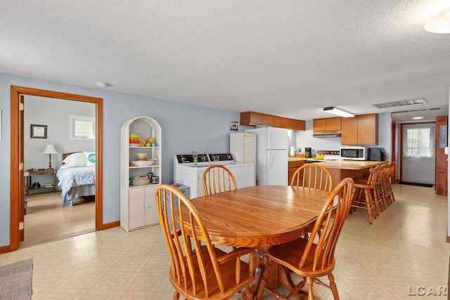 8400 Horton Beach Dr, Manitou Beach, MI 49253 - dining space featuring washing machine and dryer, light flooring, a textured ceiling, healthy amount of natural light, and baseboards