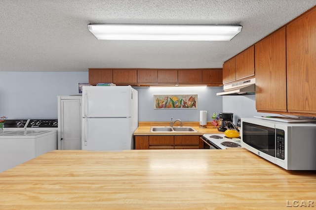 8400 Horton Beach Dr, Manitou Beach, MI 49253 - kitchen featuring white appliances, washing machine and dryer, a sink, under cabinet range hood, and a textured ceiling