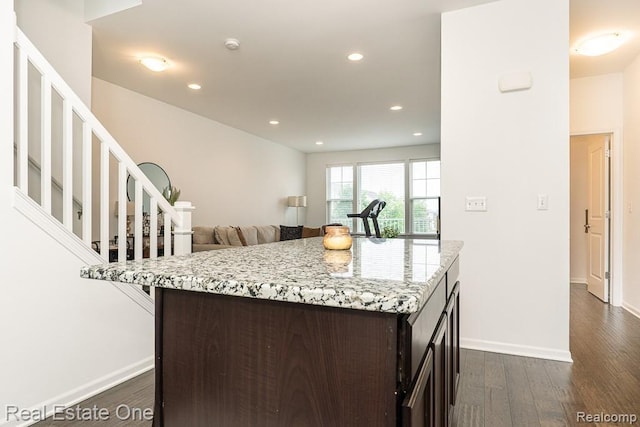 4661 Bradley Cir, Troy, MI 48085 - kitchen with dark brown cabinets, dark wood finished floors, recessed lighting, light stone countertops, and a kitchen island