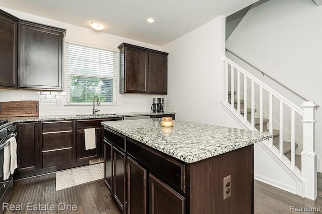 4661 Bradley Cir, Troy, MI 48085 - kitchen featuring a sink, dark wood-style floors, backsplash, light stone countertops, and a kitchen island