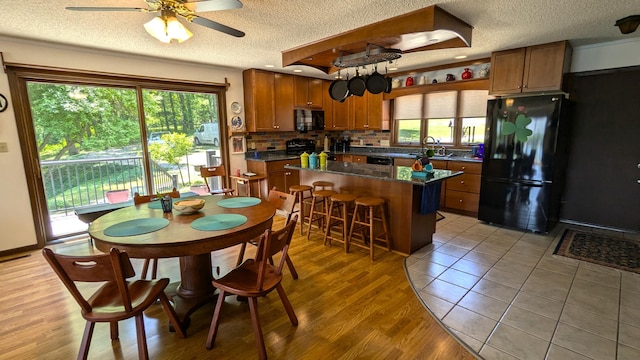 66109 Hideaway Ln, Sturgis, MI 49091 - kitchen featuring black appliances, a textured ceiling, a sink, dark countertops, and a ceiling fan