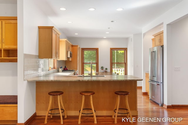 2229 Brighton St, Holland, MI 49424 - kitchen featuring stainless steel appliances, a peninsula, recessed lighting, wood finished floors, and a sink