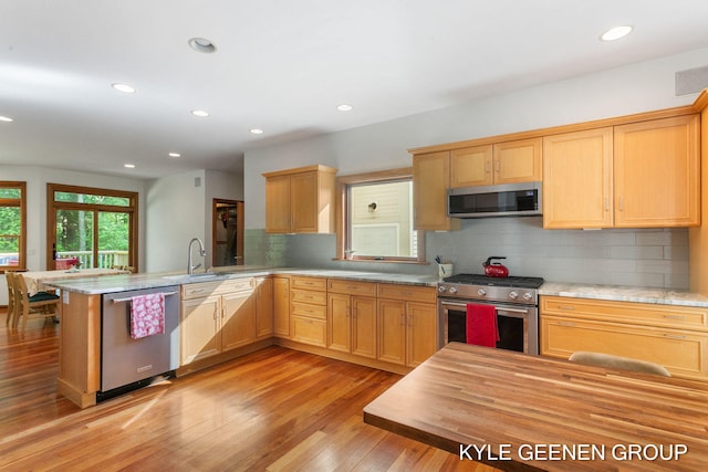 2229 Brighton St, Holland, MI 49424 - kitchen featuring stainless steel appliances, a sink, recessed lighting, light wood finished floors, and backsplash