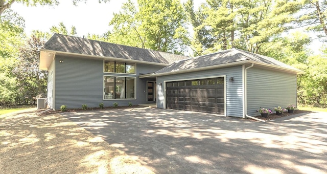 2971 Daleview Dr, Ann Arbor, MI 48105 - view of front of home featuring asphalt driveway, an attached garage, central AC, and a shingled roof
