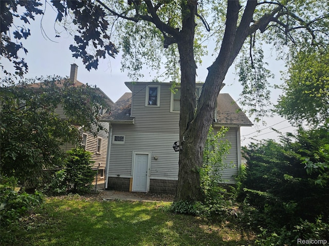 48 W Charlotte St, Ecorse, MI 48229 - back of house featuring a shingled roof and a yard