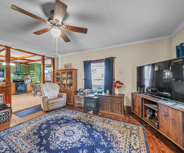 405 E Saginaw St, Saint Louis, MI 48880 - living room featuring ornamental molding, a ceiling fan, wood finished floors, a wood stove, and a textured ceiling