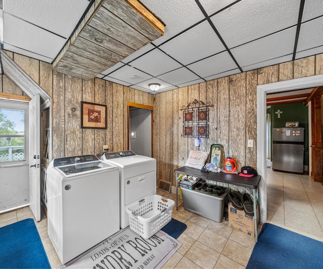 405 E Saginaw St, Saint Louis, MI 48880 - washroom featuring light tile patterned floors, washing machine and clothes dryer, and wooden walls