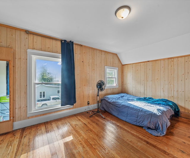 405 E Saginaw St, Saint Louis, MI 48880 - bedroom featuring wood-type flooring, vaulted ceiling, and wooden walls