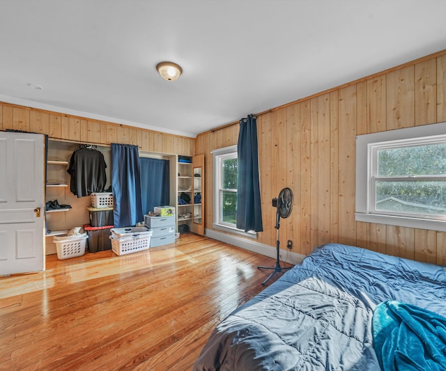 405 E Saginaw St, Saint Louis, MI 48880 - bedroom featuring wood walls, multiple windows, hardwood / wood-style flooring, and ornamental molding