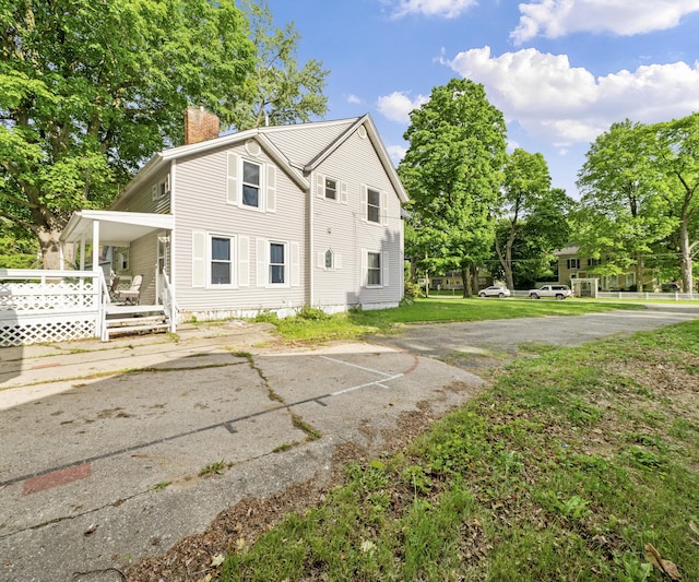 405 E Saginaw St, Saint Louis, MI 48880 - view of side of home featuring a chimney and covered porch