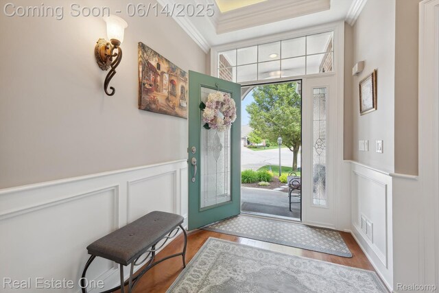 446 Delmar Ct, Highland, MI 48357 - entryway featuring crown molding, a decorative wall, a wainscoted wall, and wood finished floors