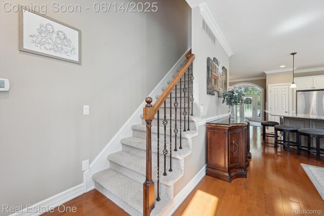 446 Delmar Ct, Highland, MI 48357 - stairs with crown molding, wood finished floors, and baseboards