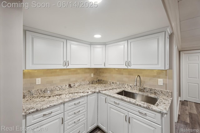446 Delmar Ct, Highland, MI 48357 - kitchen with a sink, white cabinets, dark wood-style flooring, backsplash, and light stone countertops