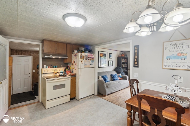 7131 Houghton Dr, Davison, MI 48423 - kitchen with white appliances, under cabinet range hood, brown cabinetry, and hanging light fixtures