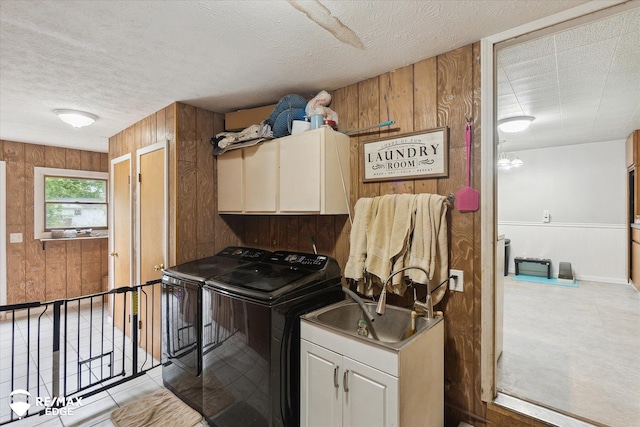 7131 Houghton Dr, Davison, MI 48423 - laundry room with cabinet space, wooden walls, washing machine and dryer, a textured ceiling, and light tile patterned floors