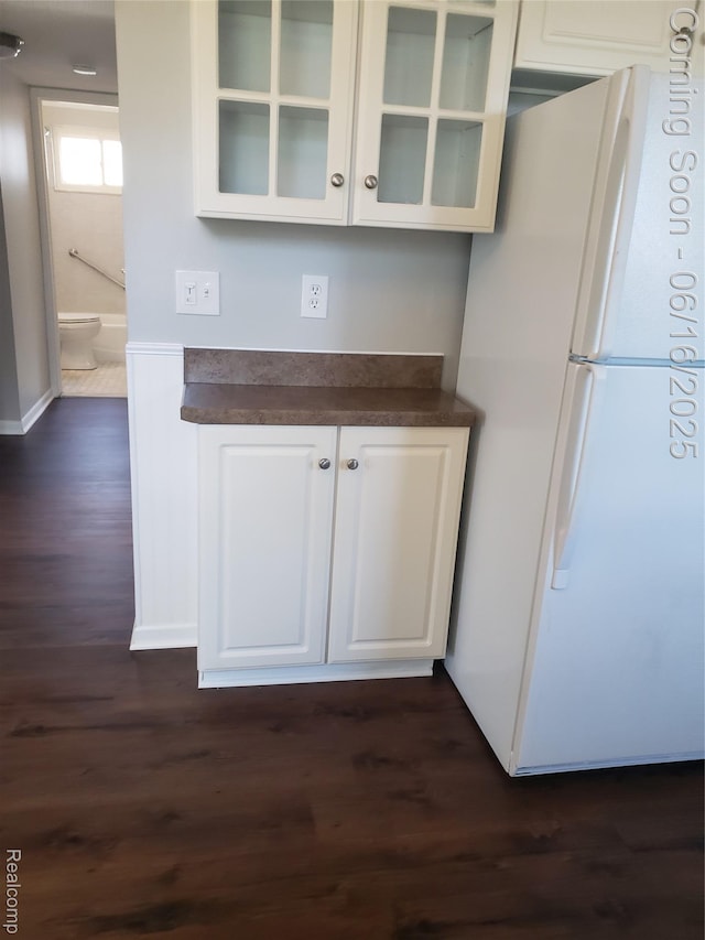 8224 Milburn St, Westland, MI 48185 - kitchen featuring freestanding refrigerator, dark countertops, dark wood-style floors, glass insert cabinets, and white cabinetry
