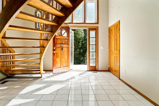4693 Gallagher Rd, Rochester, MI 48306 - foyer with baseboards, stairs, light tile patterned floors, and a towering ceiling