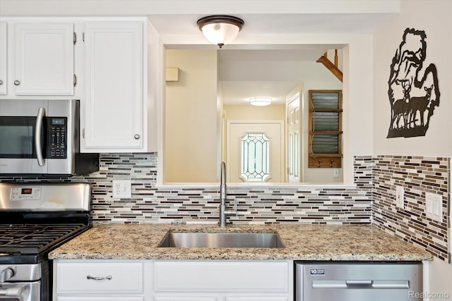 43687 Christopher Ct, Canton, MI 48188 - kitchen with appliances with stainless steel finishes, a sink, decorative backsplash, white cabinetry, and light stone counters