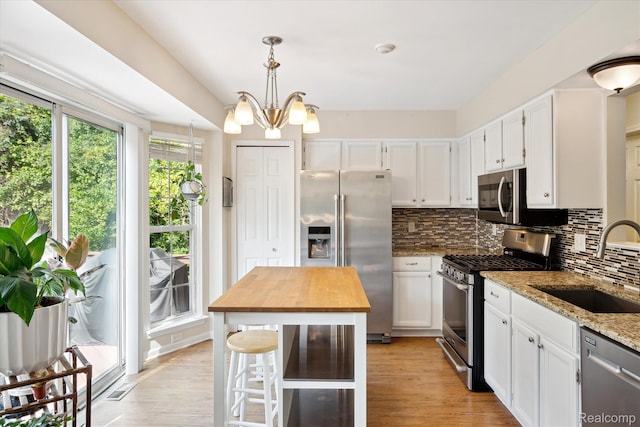 43687 Christopher Ct, Canton, MI 48188 - kitchen with appliances with stainless steel finishes, a sink, light stone countertops, tasteful backsplash, and white cabinetry