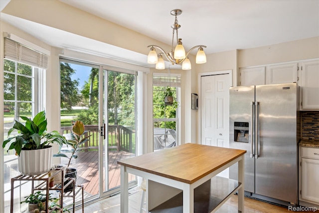 43687 Christopher Ct, Canton, MI 48188 - kitchen with stainless steel fridge, butcher block countertops, backsplash, and white cabinetry