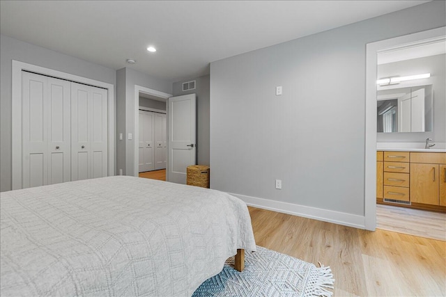 4067 Hillside Trl, New Buffalo, MI 49117 - bedroom featuring a sink, light wood-style floors, baseboards, connected bathroom, and recessed lighting