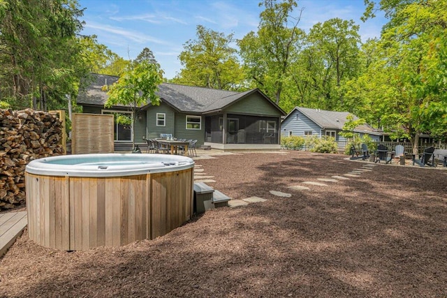 4067 Hillside Trl, New Buffalo, MI 49117 - back of property with a hot tub, a sunroom, and roof with shingles