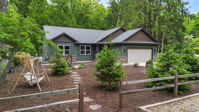 4067 Hillside Trl, New Buffalo, MI 49117 - view of front of property featuring a garage, driveway, stone siding, and roof with shingles