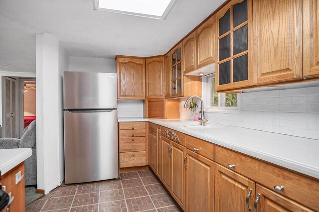 4468 Teal Ln, Newaygo, MI 49337 - kitchen with freestanding refrigerator, a sink, tasteful backsplash, light countertops, and brown cabinets
