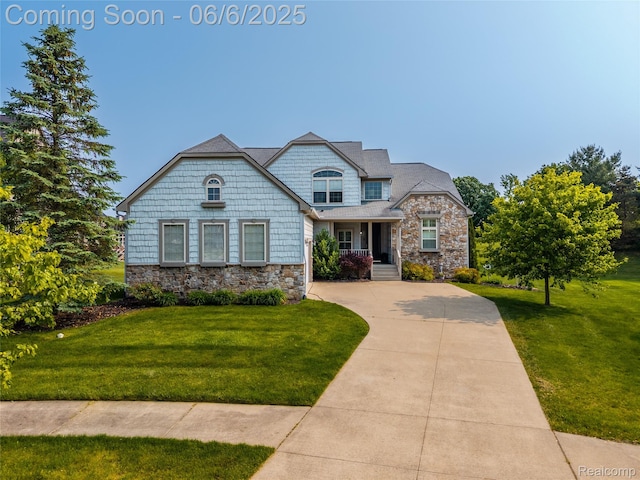 2327 Cherry Tree Ln, Grand Blanc, MI 48439 - view of front facade with stone siding, a front lawn, and concrete driveway