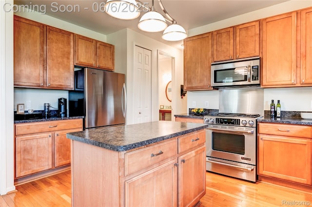 2327 Cherry Tree Ln, Grand Blanc, MI 48439 - kitchen with stainless steel appliances, dark countertops, light wood-type flooring, a kitchen island, and hanging light fixtures