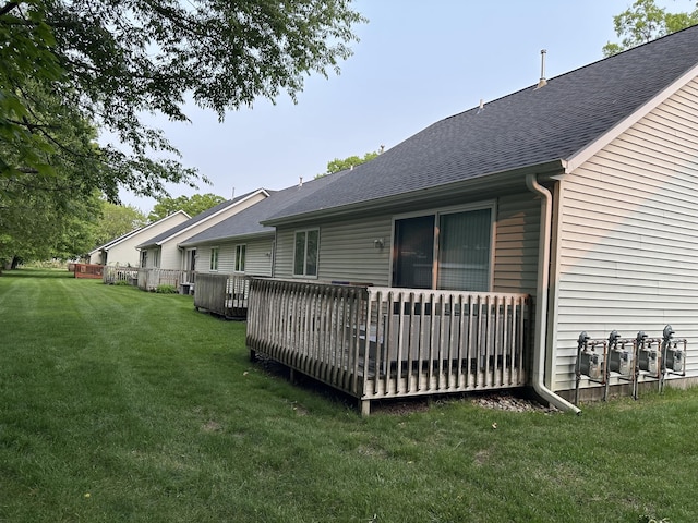 335 Nestlewood Dr, Holland, MI 49424 - rear view of house with roof with shingles, a lawn, and a wooden deck