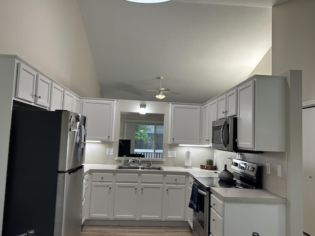 335 Nestlewood Dr, Holland, MI 49424 - kitchen with stainless steel appliances, a sink, a ceiling fan, vaulted ceiling, and light countertops