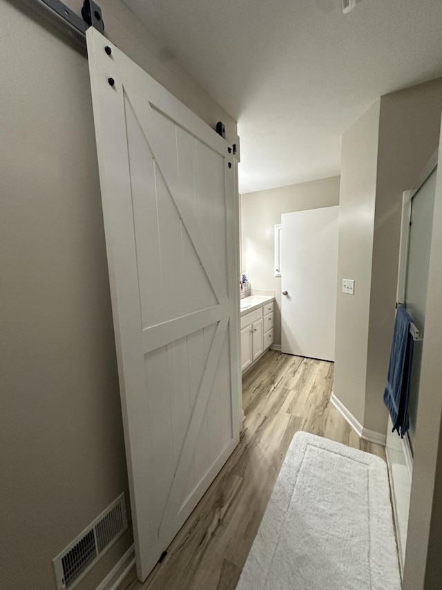 335 Nestlewood Dr, Holland, MI 49424 - bathroom featuring vanity, wood finished floors, and baseboards
