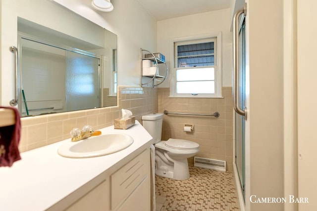 5053 Jonfield Ave SE, Grand Rapids, MI 49548 - full bathroom with toilet, a shower with shower door, vanity, tile walls, and tile patterned floors