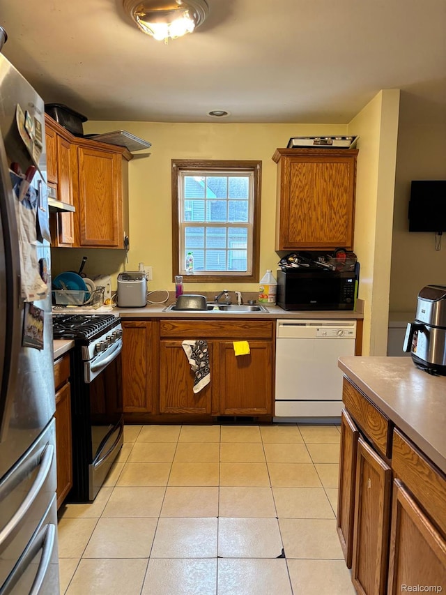 15803 Tireman St, Detroit, MI 48228 - kitchen with dishwasher, freestanding refrigerator, stainless steel range with gas stovetop, black microwave, and brown cabinetry