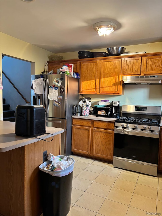 15803 Tireman St, Detroit, MI 48228 - kitchen with appliances with stainless steel finishes, under cabinet range hood, brown cabinetry, and light tile patterned floors