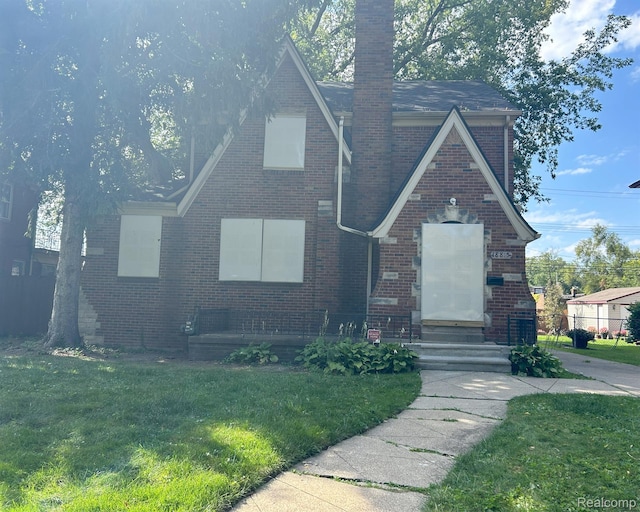 18815 Lancashire St, Detroit, MI 48223 - english style home featuring brick siding, a front yard, and a chimney
