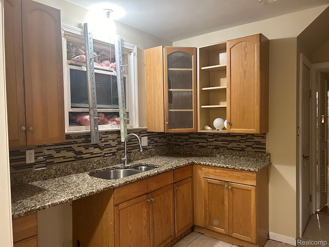 18815 Lancashire St, Detroit, MI 48223 - kitchen featuring a sink, dark stone counters, tasteful backsplash, and light tile patterned floors