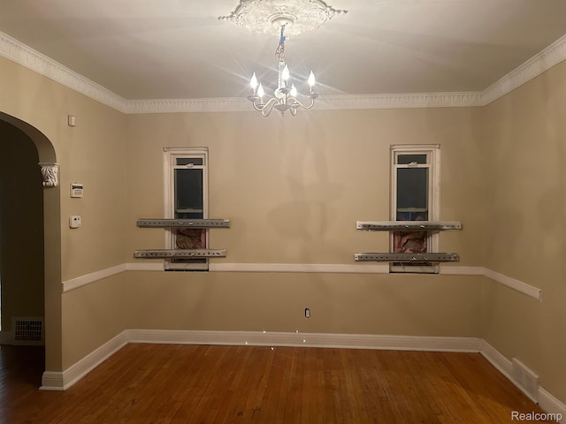 18815 Lancashire St, Detroit, MI 48223 - empty room featuring arched walkways, a chandelier, wood finished floors, ornamental molding, and baseboards