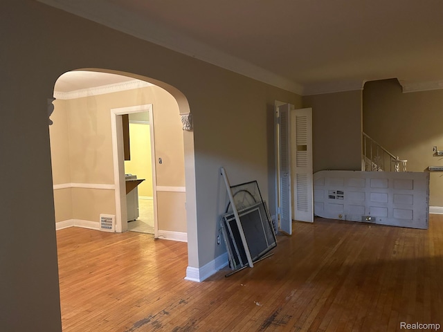 18815 Lancashire St, Detroit, MI 48223 - unfurnished room featuring arched walkways, hardwood / wood-style floors, crown molding, baseboards, and stairs