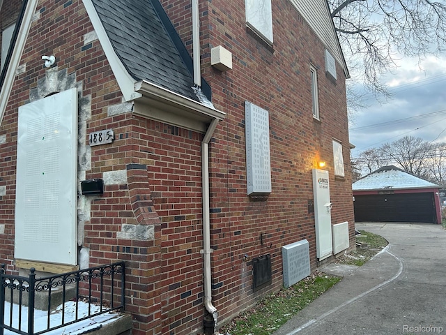 18815 Lancashire St, Detroit, MI 48223 - view of side of home with brick siding, a garage, an outbuilding, and a shingled roof