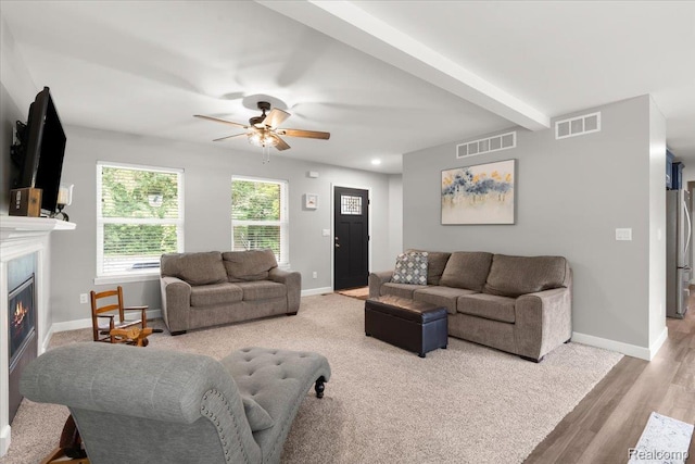 2230 Briar Rdg, Wolverine Lake, MI 48390 - living room featuring a glass covered fireplace, baseboards, a ceiling fan, light carpet, and light wood-style flooring