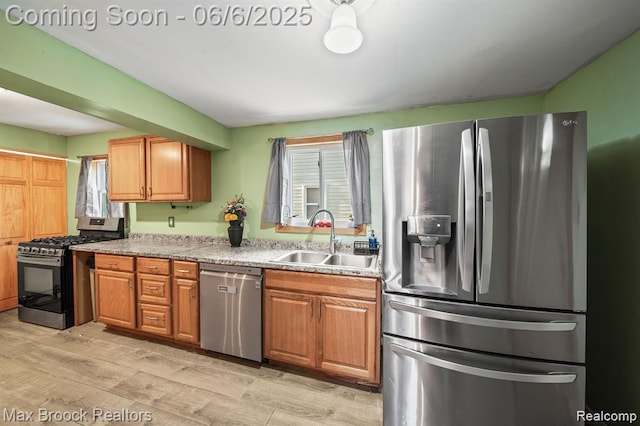 7713 Jackson St, Taylor, MI 48180 - kitchen with stainless steel appliances, a sink, light wood-style floors, and brown cabinets