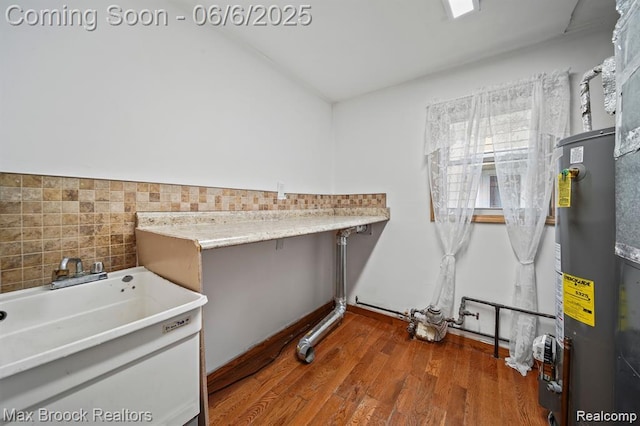 7713 Jackson St, Taylor, MI 48180 - laundry area with gas water heater, wood finished floors, and a sink