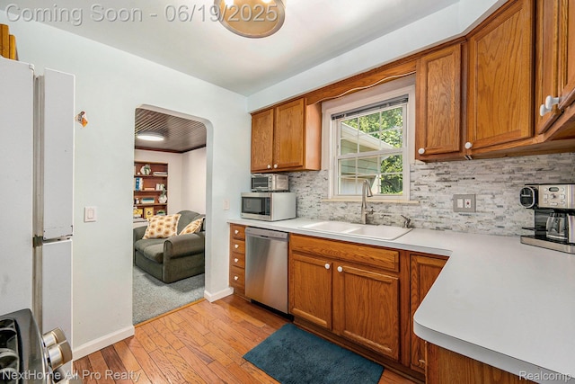 36551 Parkdale St, Livonia, MI 48150 - kitchen featuring appliances with stainless steel finishes, light wood-type flooring, and brown cabinets