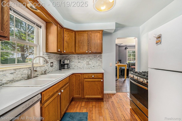 36551 Parkdale St, Livonia, MI 48150 - kitchen with appliances with stainless steel finishes, arched walkways, backsplash, and brown cabinets