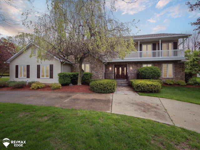 9705 Burning Tree Dr, Grand Blanc, MI 48439 - view of property with stone siding, a yard, and a balcony