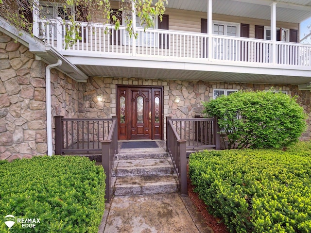 9705 Burning Tree Dr, Grand Blanc, MI 48439 - property entrance with stone siding, a porch, and a balcony