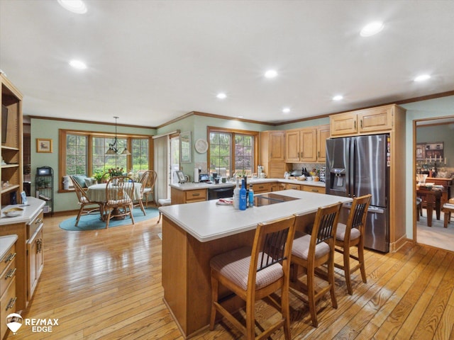 9705 Burning Tree Dr, Grand Blanc, MI 48439 - kitchen with stainless steel refrigerator with ice dispenser, ornamental molding, light countertops, light wood-type flooring, and light brown cabinetry